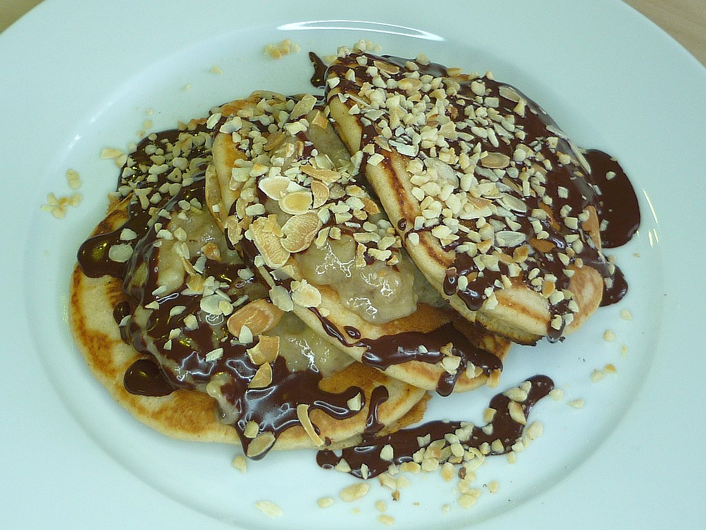 Pancakes mit Bananen, Nüssen und einer Schokoladensauce